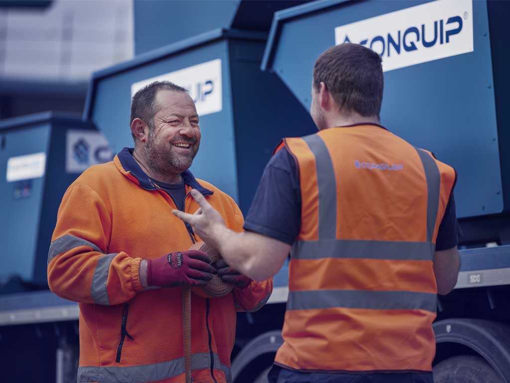 men talking next to hired equipment